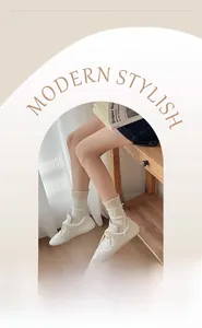 Close-up of elastic ribbed cuff on cream-colored bow socks paired with white sneakers