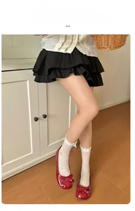 Detail view of white lace crew socks with bow hollow patterns and ruffled cuffs