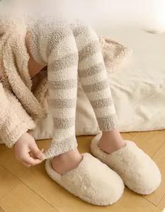 Close-up of elastic striped coral fleece leg warmers with soft plush texture for winter