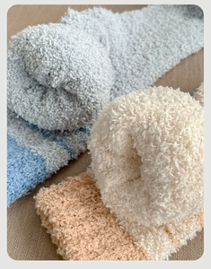 Close-up of thick coral fleece winter socks showing soft striped texture and fuzzy material