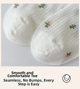 Close-up of seamless toe stitching on white cotton socks with delicate floral embroidery