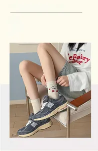 Detailed view of beige mid-tube socks with cute cat embroidery and red polka dots