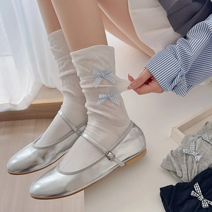 White crew socks with light blue plaid bows paired with silver Mary Jane shoes