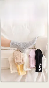 Detail of coral fleece socks with side bow ribbons on a white sofa setting