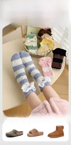 Détail de chaussettes rayées en velours corail avec un joli nœud blanc décoratif