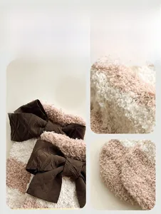 Vue détaillée de chaussettes en molleton corail avec un nœud en tricot à carreaux marron
