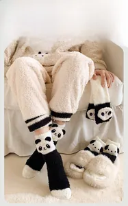 Détail de chaussettes panda en polaire corail et chaussons pour la chaleur