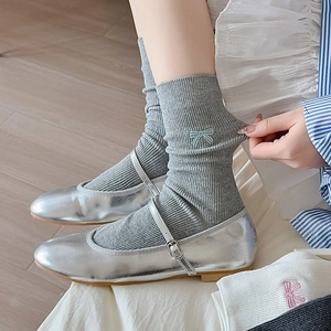 Gray ribbed crew socks featuring delicate bow embroidery paired with silver Mary Jane shoes