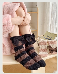 Gros plan de chaussettes d'hiver épaisses en polaire corail avec rayures et nœud
