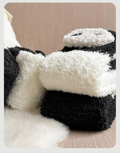 Gros plan de chaussettes panda en polaire corail épaisse avec texture douce noir et blanc