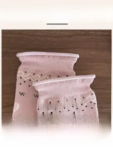 Detailed macro view of the high-elastic ribbed cuff on pink knit crew socks with patterns