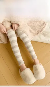 Detail of soft striped coral fleece over-knee leg warmers for cozy winter loungewear