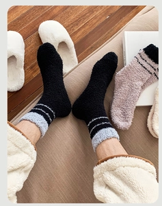 Close-up of thick coral fleece socks with stripes, perfect for home winter warmth