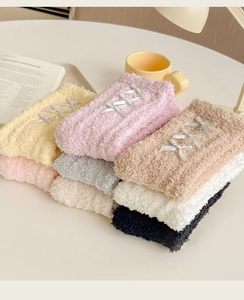 Detail of multi-colored fluffy coral fleece socks with elegant satin bow decorations