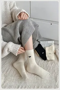 Dettaglio di calze in maglia spessa con ricamo a cuore per il comfort invernale
