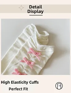 Detail of white ribbed socks featuring three small pink velvet bows and elastic cuffs