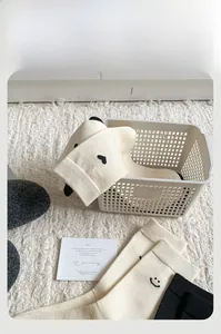 Dettaglio di calze termiche in peluche morbido con motivi di cuore e faccina nera