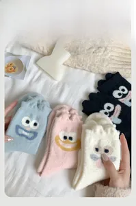 Detailed view of thick cartoon coral fleece socks in blue, pink, white, and black