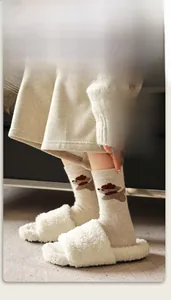 Gros plan de chaussettes en laine avec broderie chien et pantoufles en fausse fourrure
