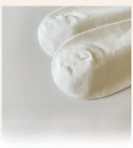 Detailed close-up of smooth seamless toe design on white cotton bow crew socks