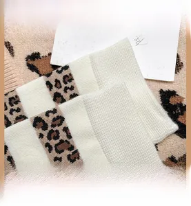 Detail von Stricksocken mit Leopardenmuster und elastischem weißem Rippbündchen für Komfort