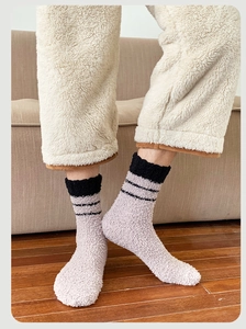 Detailed texture of thick coral fleece winter socks with black stripes on home floor