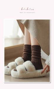 Dettaglio delle pantofole platform in peluche beige con calze pesanti invernali
