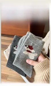 Gros plan de chaussettes en laine avec motifs de chiots de dessin animé gris