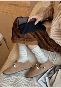 Detail showing white ribbed knit socks paired with brown suede shoes for winter fashion