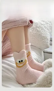 Detail of pink fleece winter socks featuring a fuzzy cartoon monster with large eyes