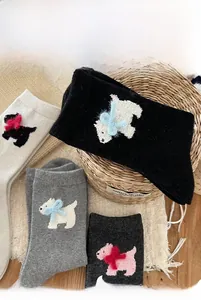 Detail of wool socks with Westie dog patterns and cute 3D bow accents for winter