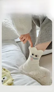 Close-up of elastic cuff and soft plush texture on white cartoon monster socks