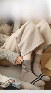 Close-up of thick wool socks featuring bear embroidery and stylish black stripes