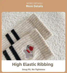 Detail of wool socks showing elastic cuffs and bear embroidery on ivory knit fabric