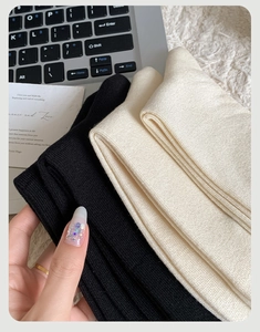 Dettaglio di calze termiche spesse in nero e beige con morbida texture a maglia a coste