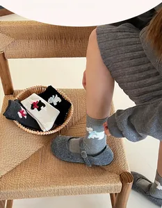 Detail of knitted dog pattern with 3D bow decoration on soft wool blend crew socks