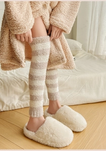Close-up of thick beige and white striped coral fleece leg warmers for winter warmth