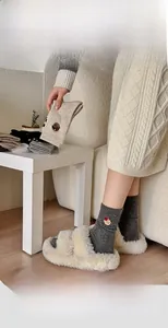 Detailed view of warm wool socks featuring cute bear embroidery in a cozy home setting