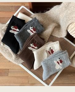 Détail de chaussettes en laine avec broderie de chien aux tons chauds d'automne