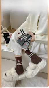 Detail showing wool-blend socks with cute bear embroidery and classic stripes texture