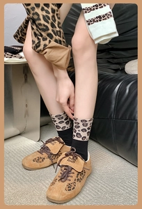 Detailansicht von Baumwollsocken mit Leopardenmuster und braunen Wildleder-Sneakern