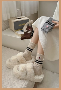 Detail of wool socks with striped cuffs and cute puppy embroidery in cozy home setting