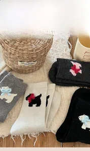 Detailed close-up of thick wool socks with cute puppy patterns and 3D bow ties