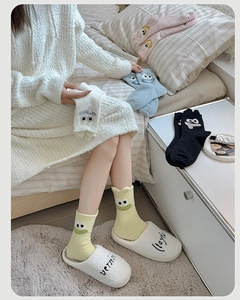Close-up of thick fleece socks with cute cartoon eyes and soft embroidered details
