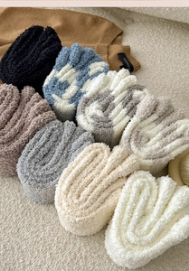 Close-up of thick coral fleece knee socks in various striped and solid winter colors