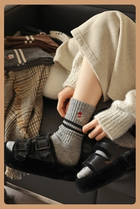 Detail of wool socks featuring cute bear embroidery and black stripes for winter warmth