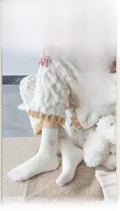 Detailaufnahme von Plüsch-Thermosocken mit rosa Herzen und gelben Punkten Muster