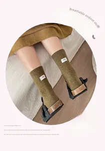 Olive green knit crew socks with egg label detail worn with black furry slippers