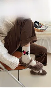 Detail of embroidered puppy wool socks paired with brown velvet Mary Jane shoes