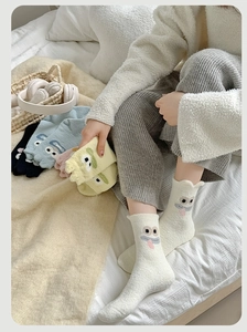 Detail of plush thermal socks with cute cartoon 3D expressions and wavy hem design
